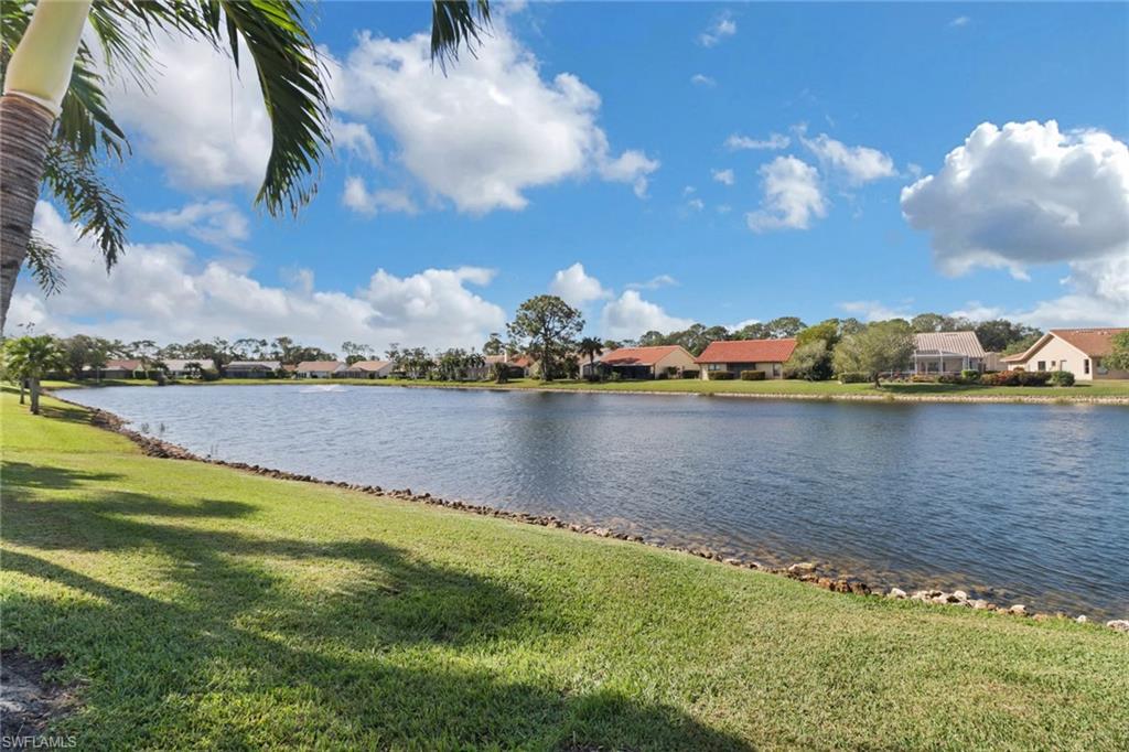 310 Fox Den Circle Naples, FL 34104 - Photo 30 of 46 a view of a lake with houses in the back