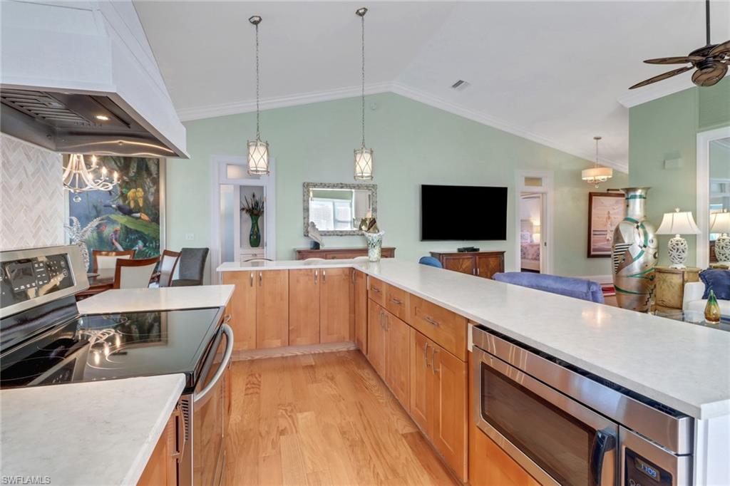 310 Fox Den Circle Naples, FL 34104 - Photo 3 of 46 a large kitchen with kitchen island a large counter space a sink appliances and a counter top space