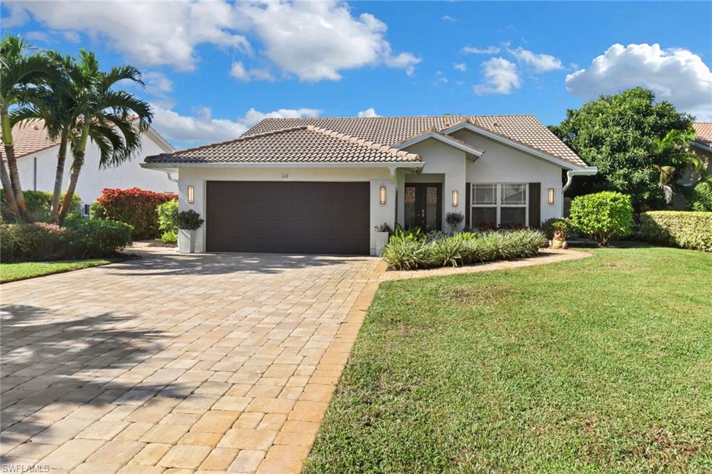 310 Fox Den Circle Naples, FL 34104 - Photo 31 of 46 a front view of a house with a garden