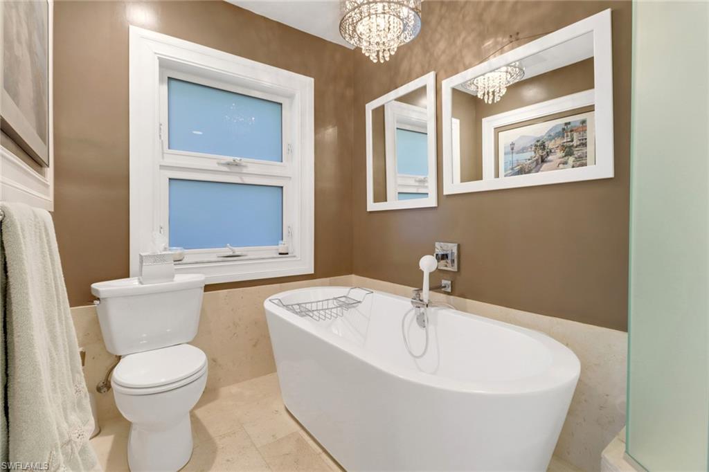 310 Fox Den Circle Naples, FL 34104 - Photo 5 of 46 a white toilet sitting next to a bathroom sink