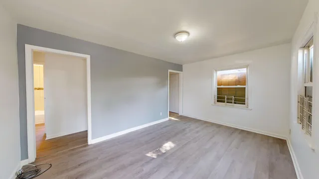 an empty room with wooden floor and a window