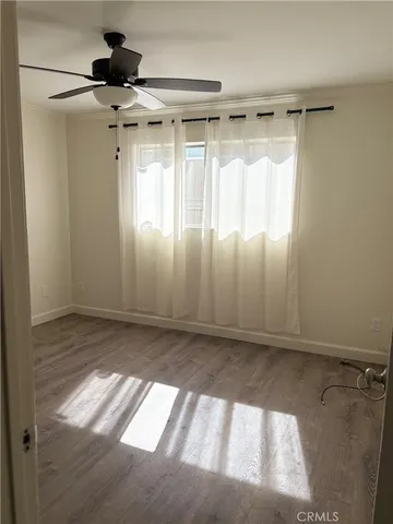a view of a room with wooden floor and a window