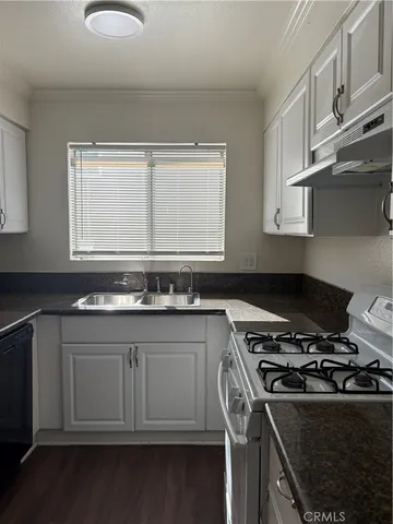 a kitchen with granite countertop a stove and a refrigerator