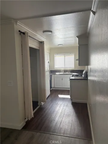 a kitchen with a refrigerator and white cabinets