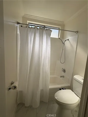 a bathroom with a shower a toilet and sink