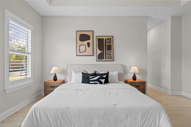 a bedroom with a bed and wooden floor