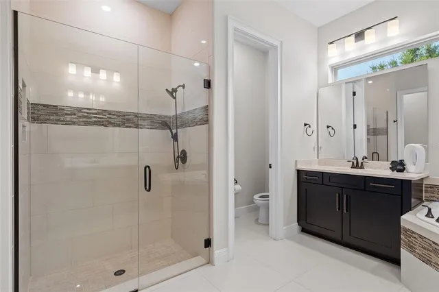 a bathroom with a double vanity sink a large mirror and shower