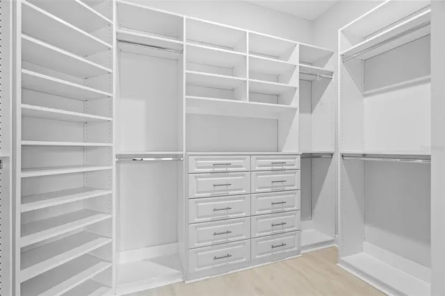 a view of walk in closet with empty racks
