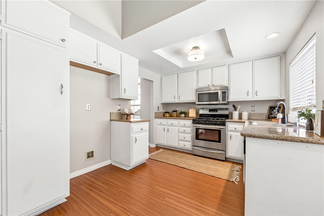 9146 Rangpur Circle Riverside, CA 92508 - Photo 23 of 52 a kitchen with granite countertop white cabinets and stainless steel appliances
