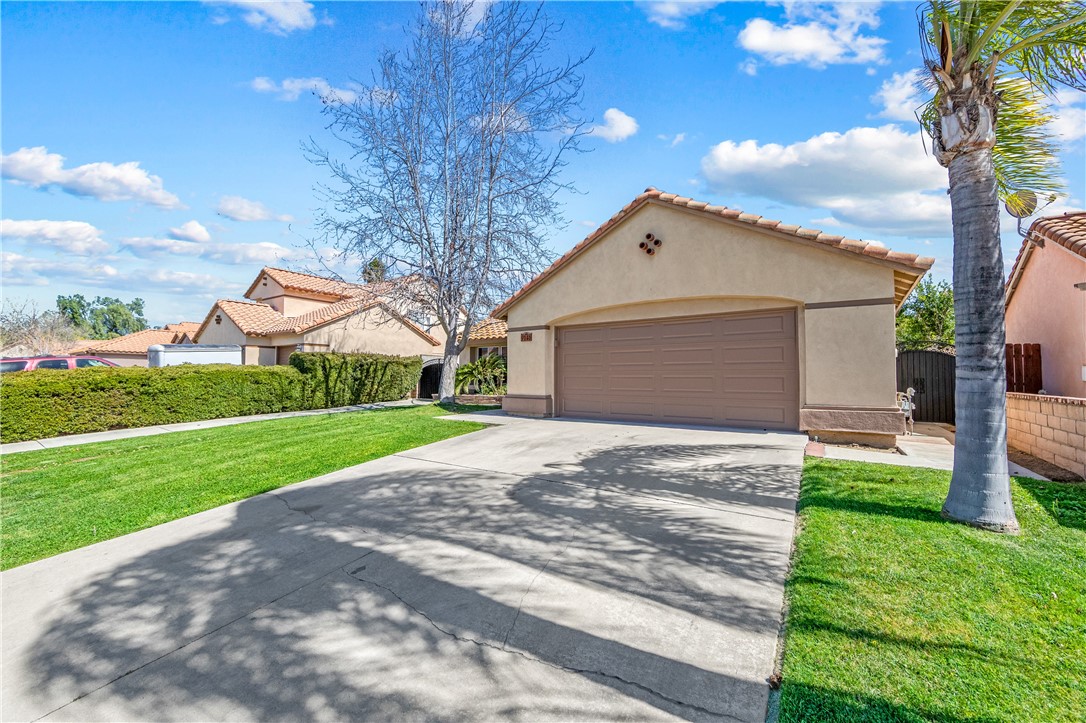 9146 Rangpur Circle Riverside, CA 92508 - Photo 7 of 52 a front view of a house with a yard and garage