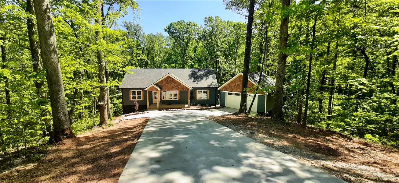 This secluded residence offers a harmonious blend of natural beauty and functional design, nestled among lush trees.