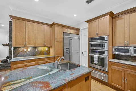 a kitchen with stainless steel appliances granite countertop a stove a sink and a refrigerator