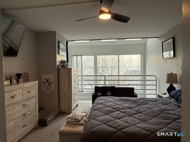 a bedroom with a bed and a large window