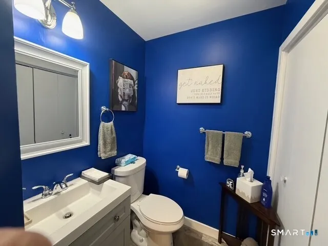 a bathroom with a toilet a sink and mirror