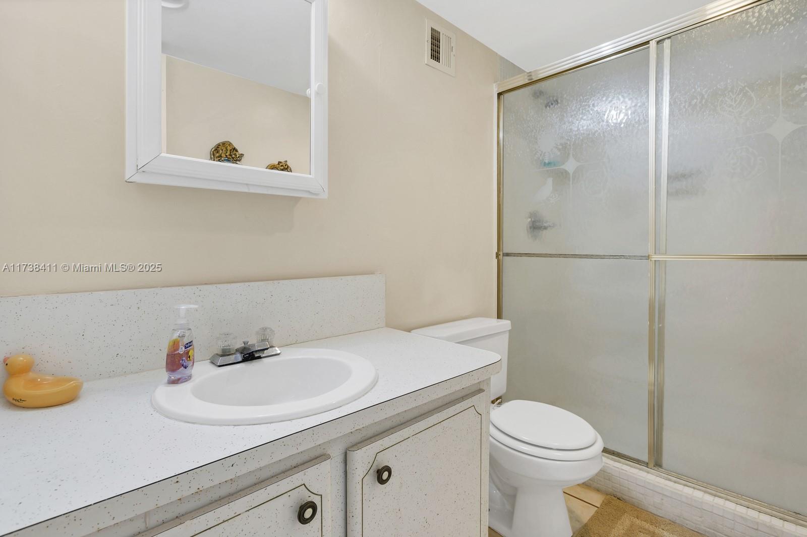 5005 Collins Avenue, Unit 724 Miami Beach, FL 33140 - Photo 11 of 15 a bathroom with a sink a toilet and shower