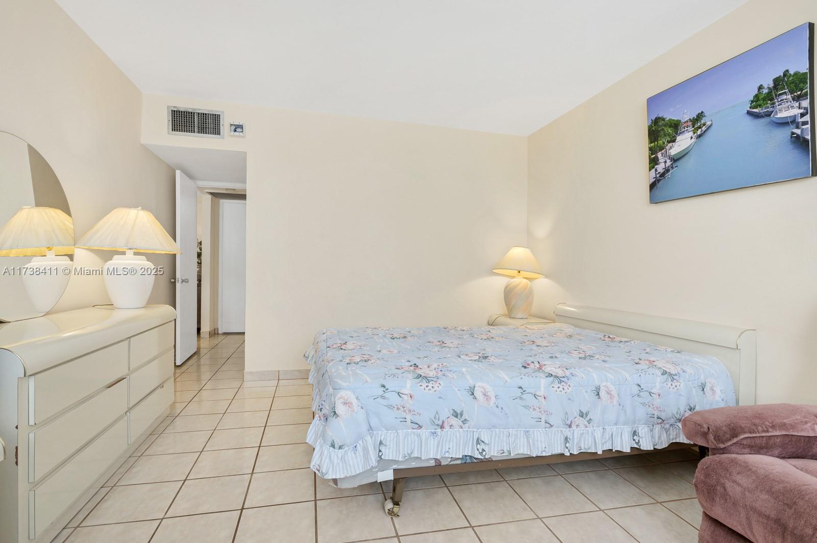 5005 Collins Avenue, Unit 724 Miami Beach, FL 33140 - Photo 13 of 15 a bedroom with a bed and a cabinets