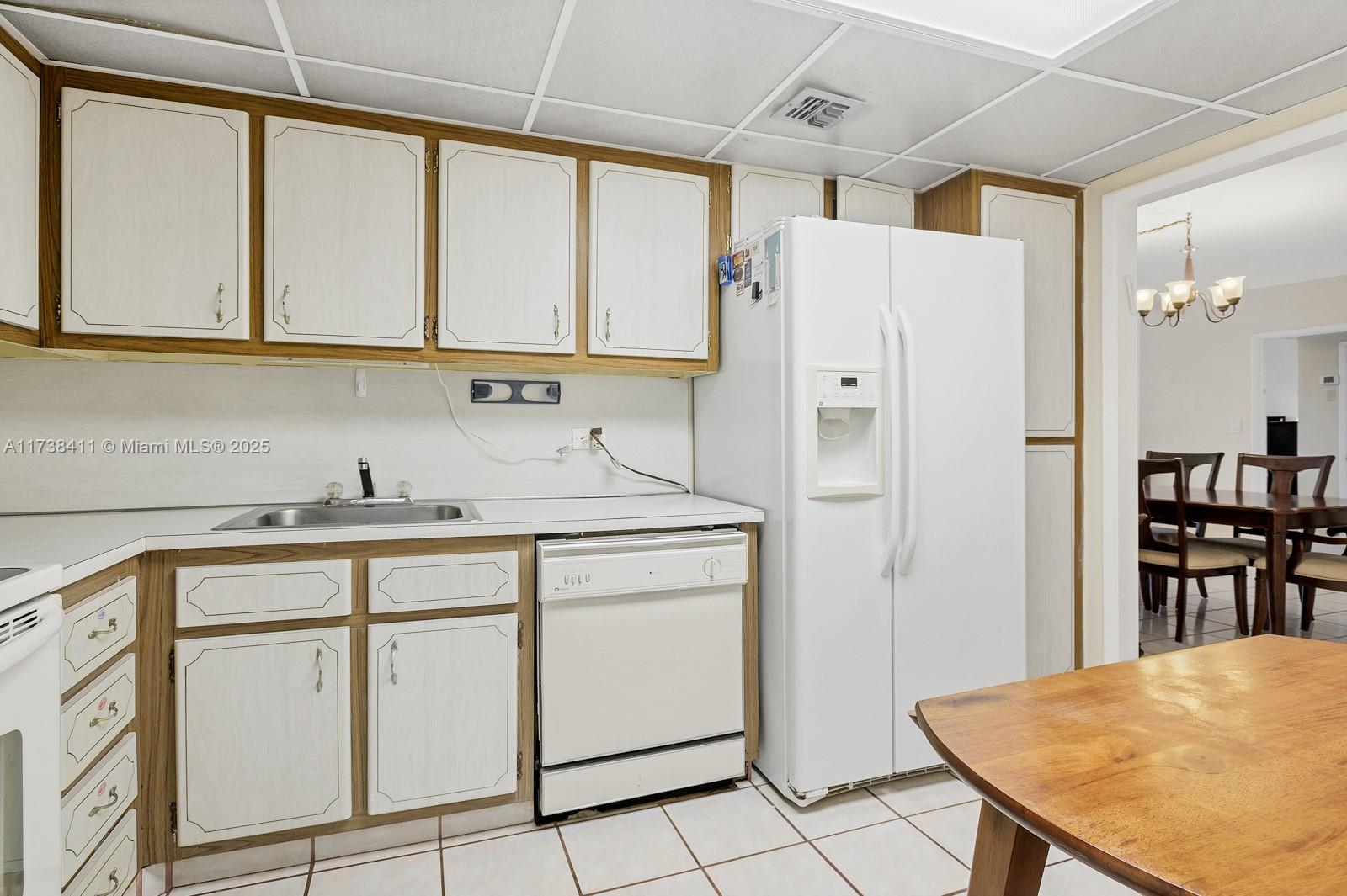 5005 Collins Avenue, Unit 724 Miami Beach, FL 33140 - Photo 7 of 15 a kitchen with white cabinets and refrigerator