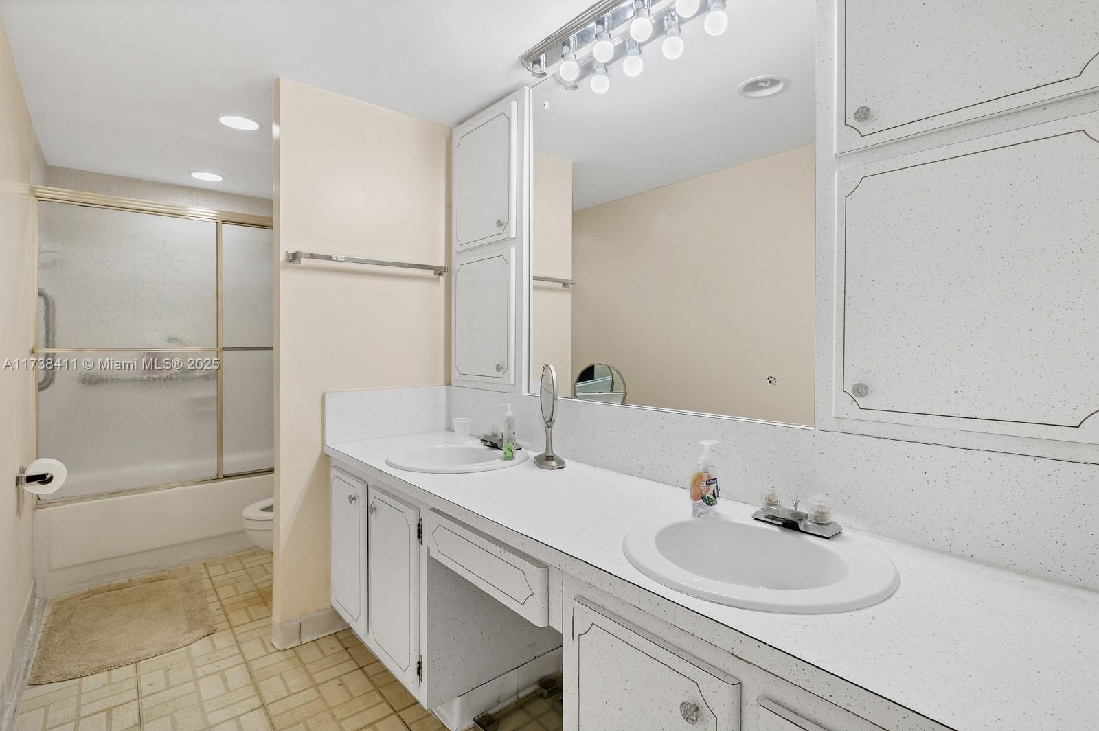 5005 Collins Avenue, Unit 724 Miami Beach, FL 33140 - Photo 10 of 15 a bathroom with a sink a toilet and shower