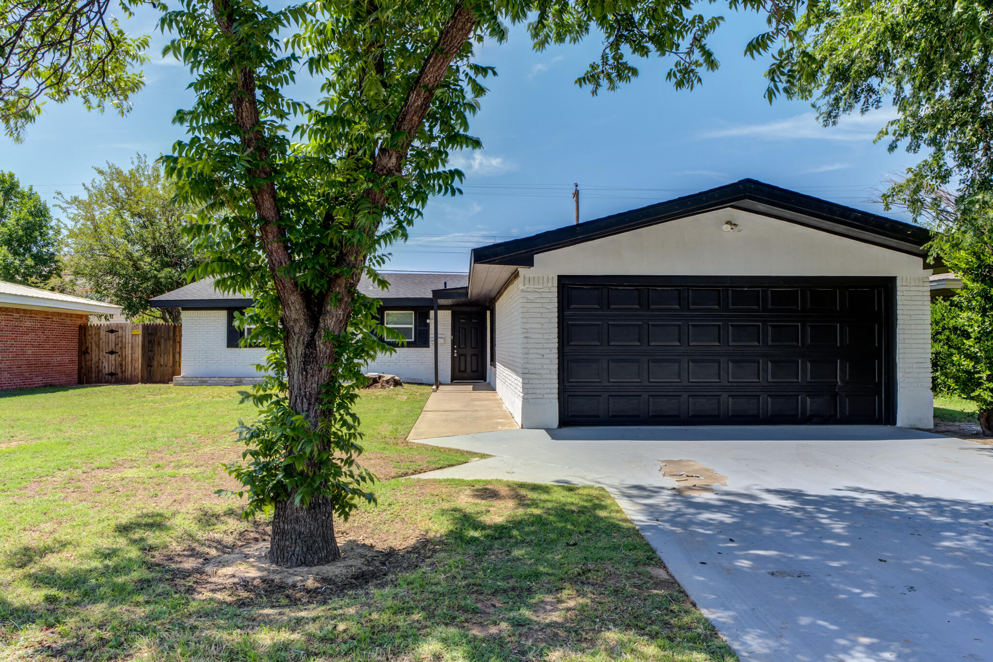 5217 9th Street Lubbock, TX 79416 - Photo 1 of 18 a front view of a house with a yard and garage