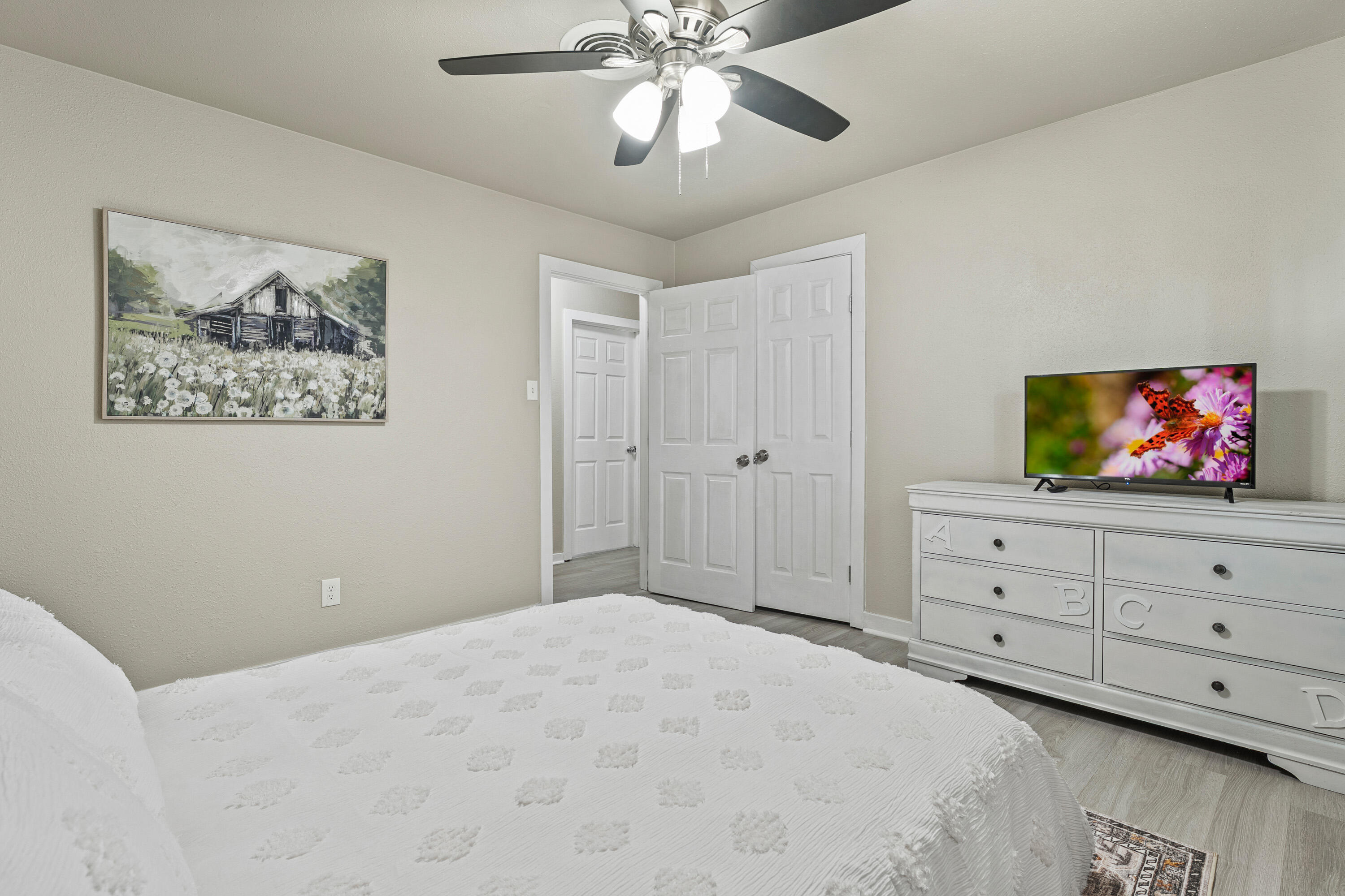 5217 9th Street Lubbock, TX 79416 - Photo 12 of 18 a bedroom with a bed and a flat screen tv