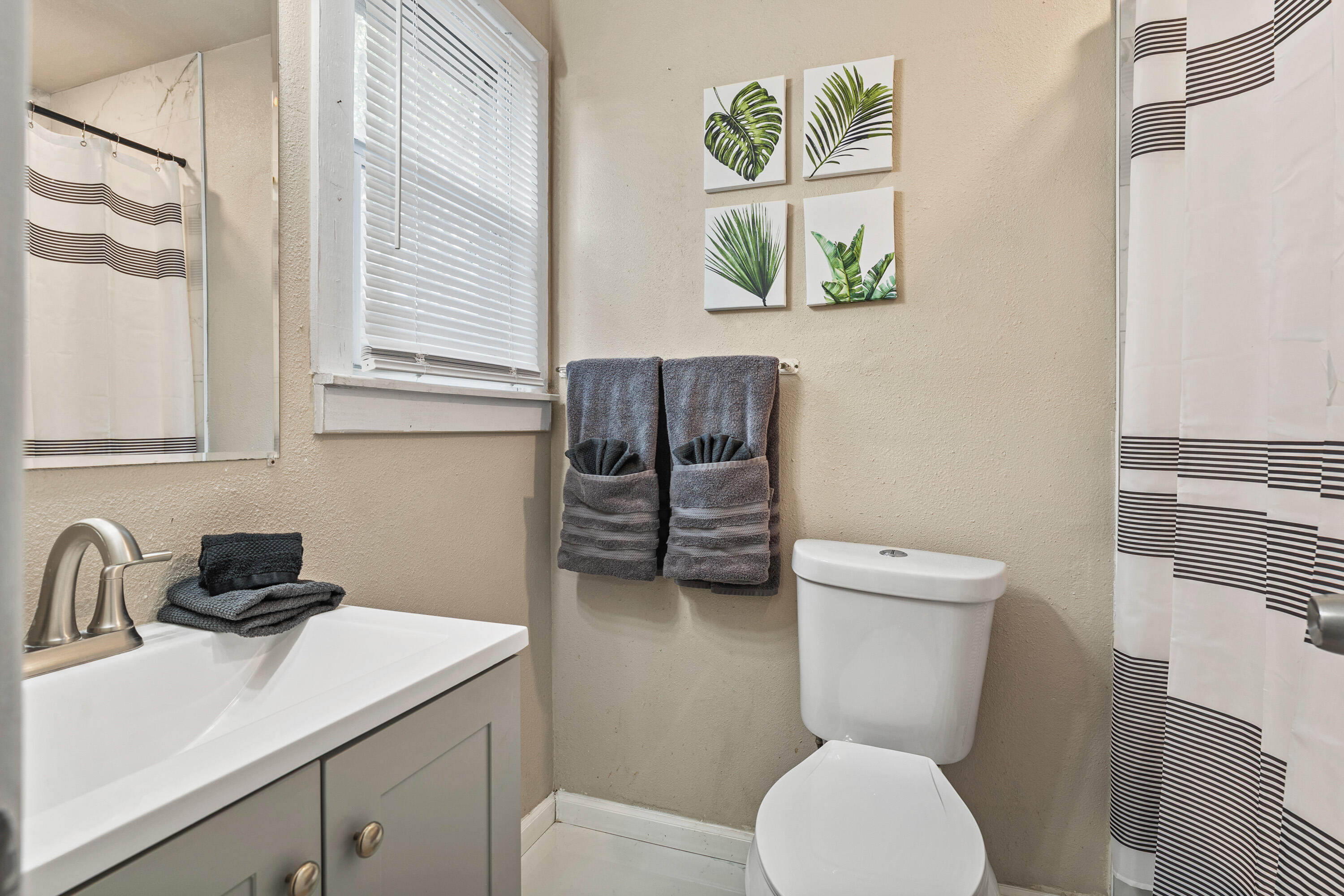 5217 9th Street Lubbock, TX 79416 - Photo 17 of 18 a bathroom with a toilet a sink and a window