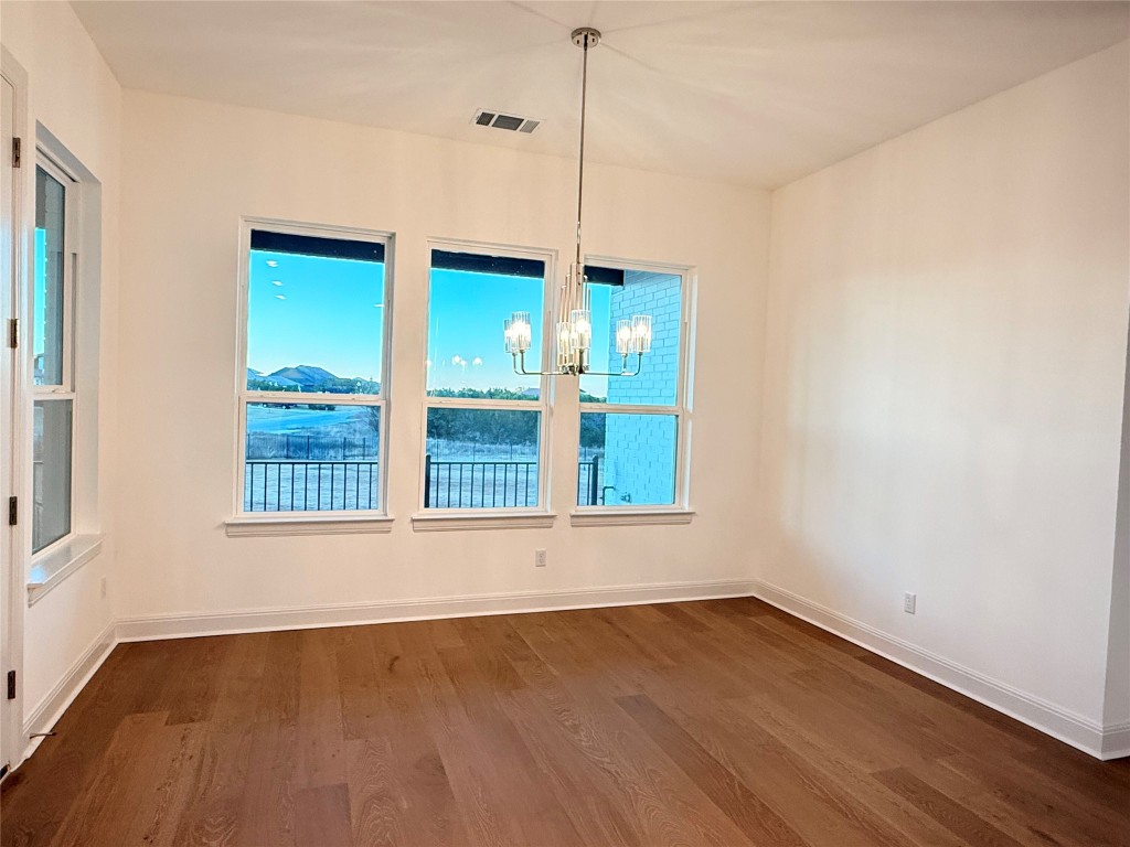 204 Rusty Colt Liberty Hill, TX 78642 - Photo 9 of 20 a view of an empty room with wooden floor and a window