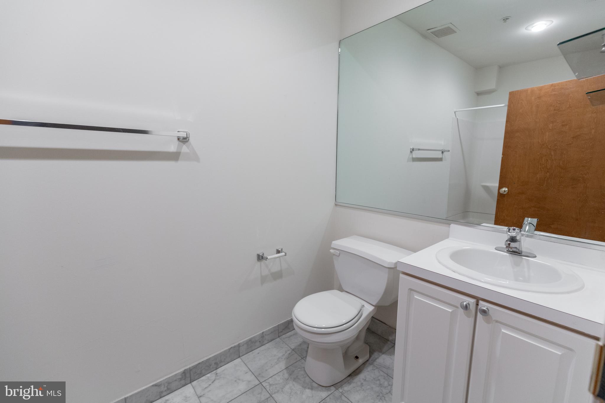 1411-5 Walnut Street, Unit 1002 Philadelphia, PA 19102 - Photo 18 of 20 a bathroom with a sink a toilet and vanity