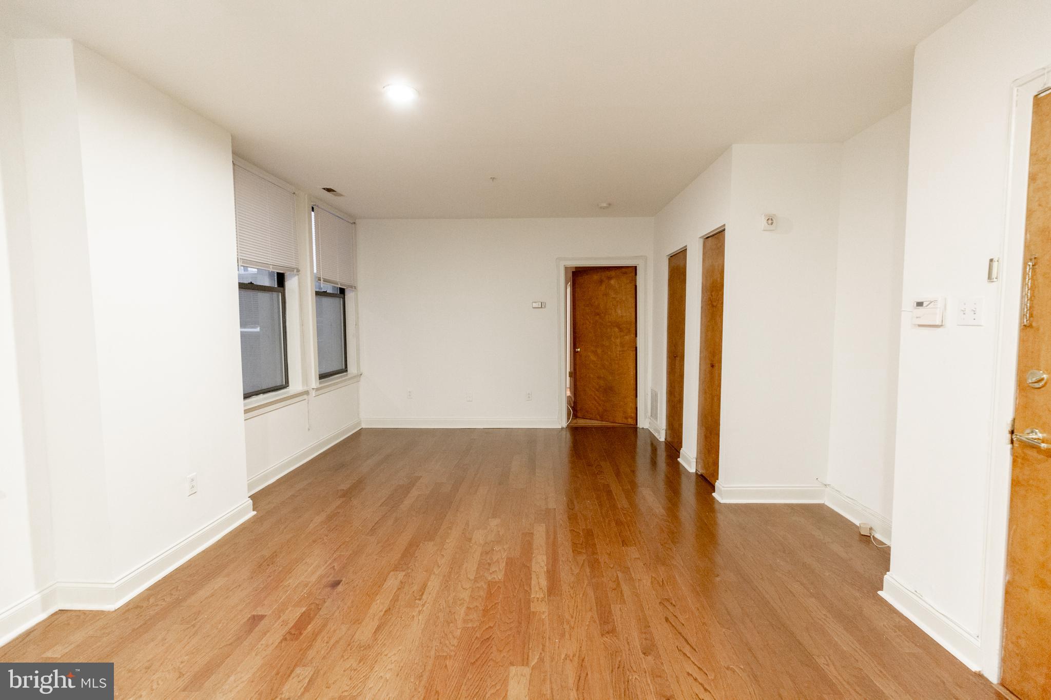 1411-5 Walnut Street, Unit 1002 Philadelphia, PA 19102 - Photo 6 of 20 a view of an empty room with wooden floor and a window