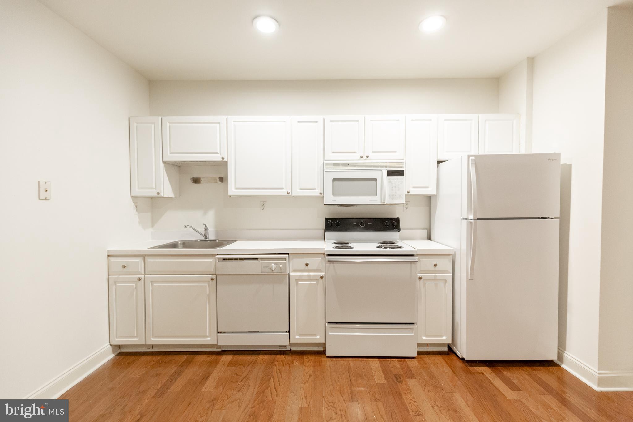 1411-5 Walnut Street, Unit 1002 Philadelphia, PA 19102 - Photo 8 of 20 a kitchen with stainless steel appliances a refrigerator stove microwave and cabinets