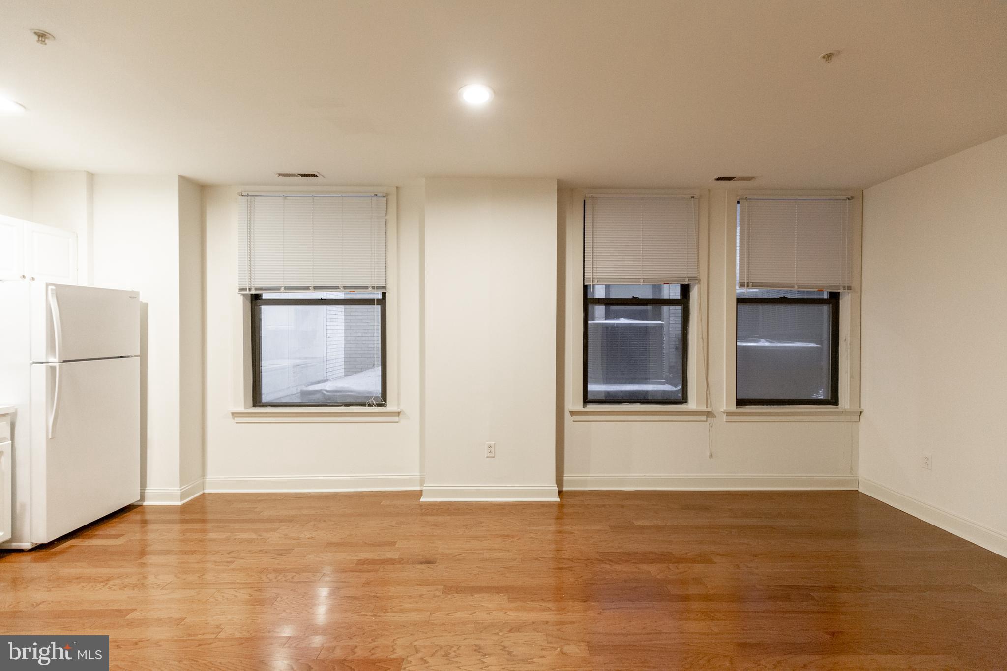 1411-5 Walnut Street, Unit 1002 Philadelphia, PA 19102 - Photo 9 of 20 a view of an empty room with a kitchen and wooden floor