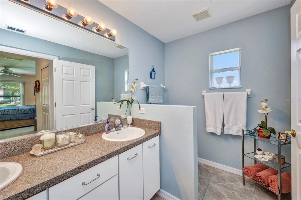24419 Buckingham Way Punta Gorda, FL 33980 - Photo 14 of 40 a en suite bathroom with double sink and a mirror