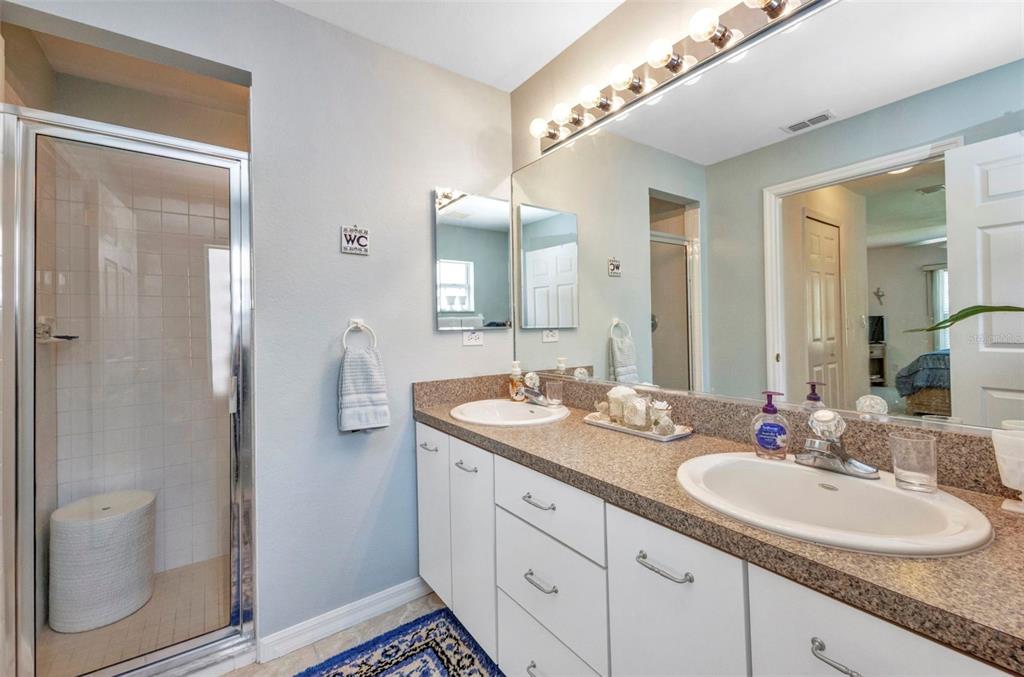 24419 Buckingham Way Punta Gorda, FL 33980 - Photo 15 of 40 a bathroom with a double vanity sink and mirror with toilet