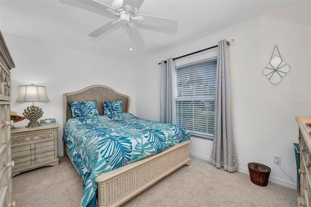 24419 Buckingham Way Punta Gorda, FL 33980 - Photo 17 of 40 a bedroom with a bed and a chandelier