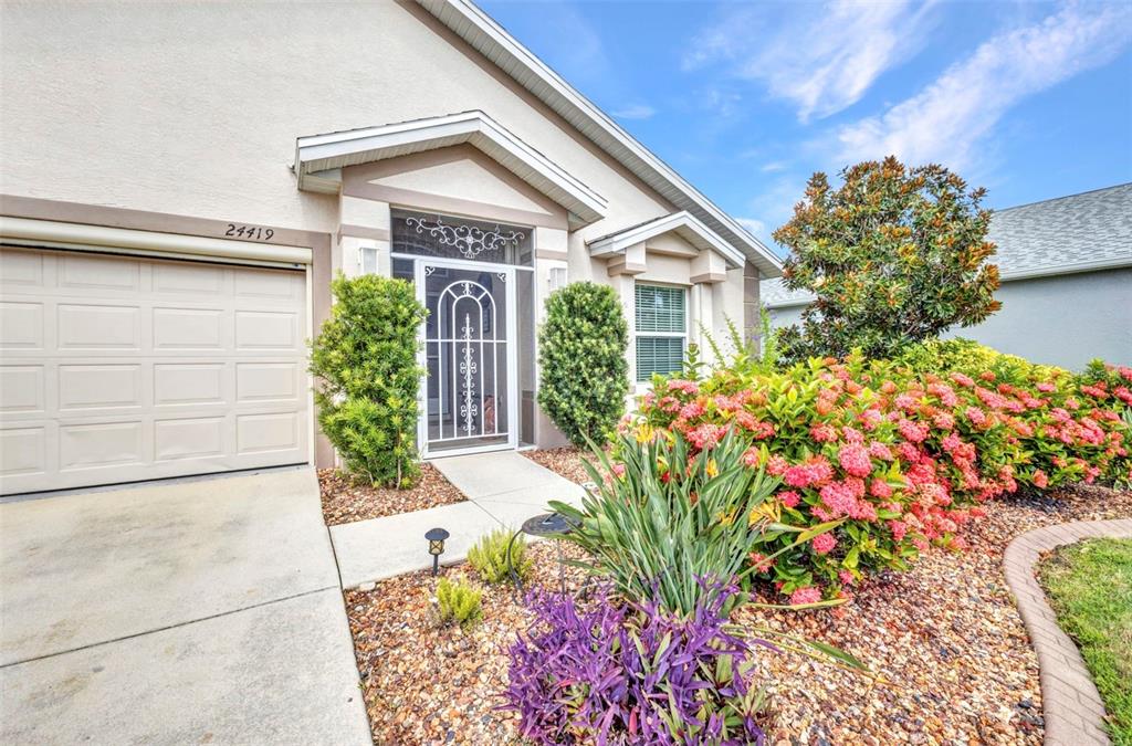 24419 Buckingham Way Punta Gorda, FL 33980 - Photo 2 of 40 a front view of a house with a flower garden