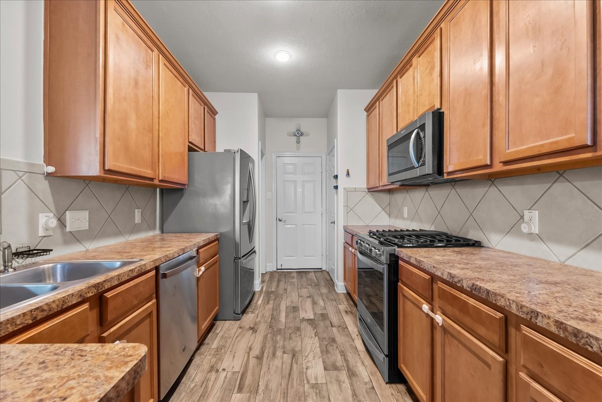 11931 Keystone Spring Way Houston, TX 77089 - Photo 12 of 34 a kitchen with stainless steel appliances granite countertop wooden cabinets a stove top oven a sink and dishwasher
