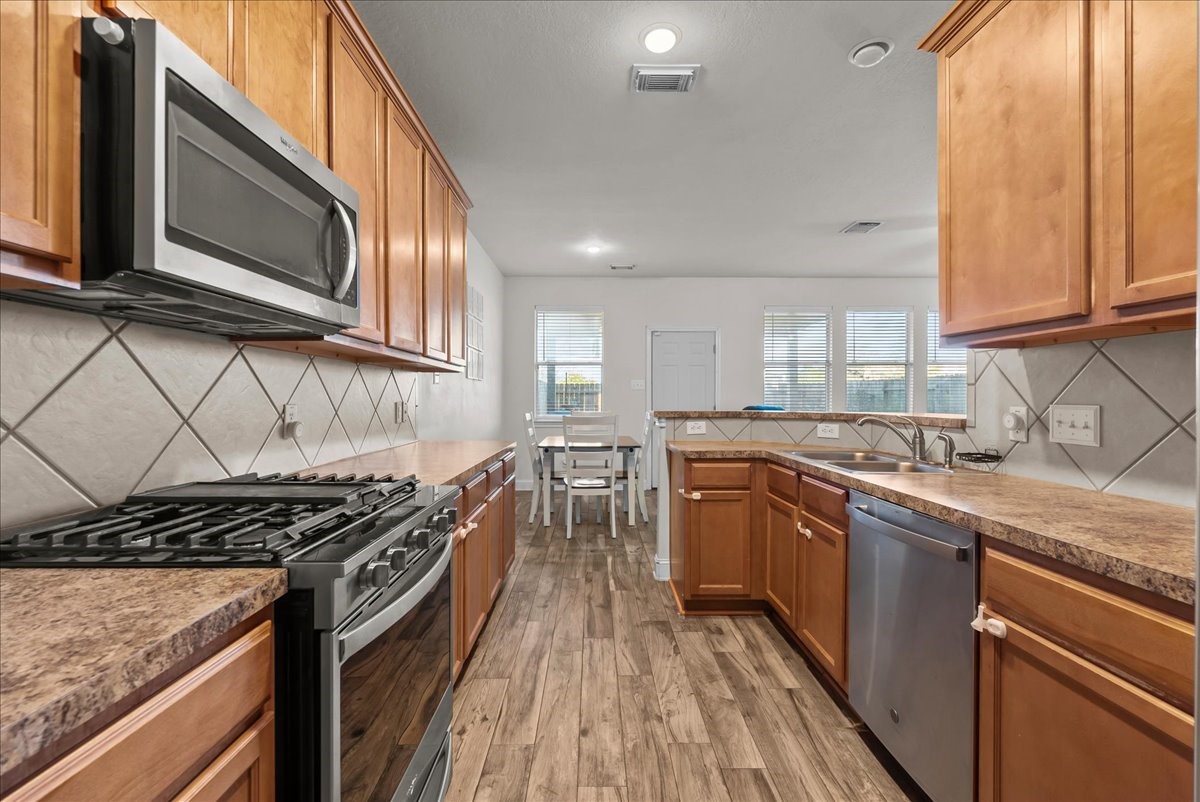 11931 Keystone Spring Way Houston, TX 77089 - Photo 13 of 34 a kitchen with stainless steel appliances granite countertop a stove a sink and a microwave