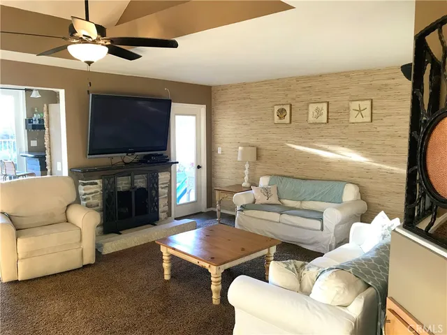 a living room with furniture a flat screen tv and a fireplace