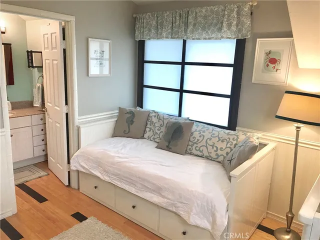 a bedroom with a bed and a flat tv screen on dresser