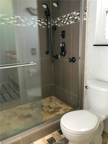 a bathroom with a toilet and a shower