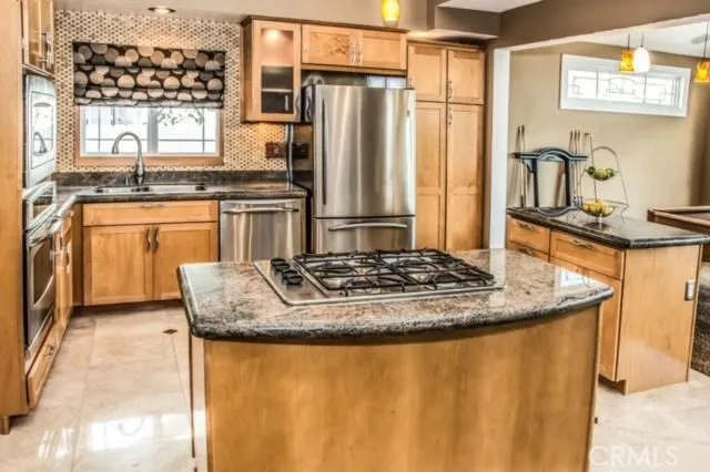 a kitchen with stainless steel appliances granite countertop a sink stove and refrigerator