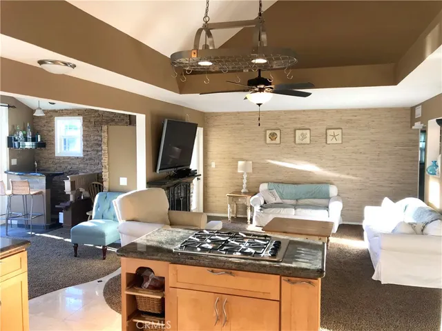 a kitchen with stainless steel appliances granite countertop a stove and a view of living room