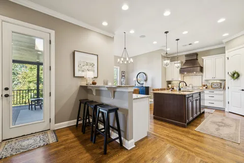 a living room with stainless steel appliances kitchen island granite countertop furniture and a large window