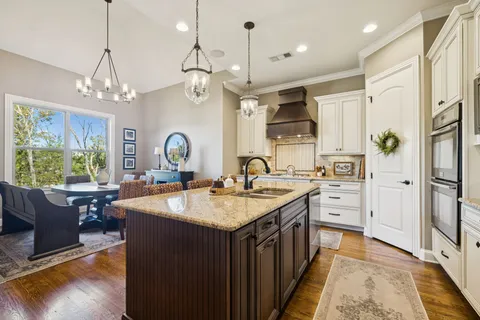 a living room with furniture large windows and wooden floor