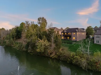 an aerial view of a house with a yard lake view and lake view