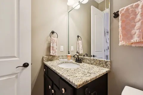a bathroom with a granite countertop sink toilet and shower