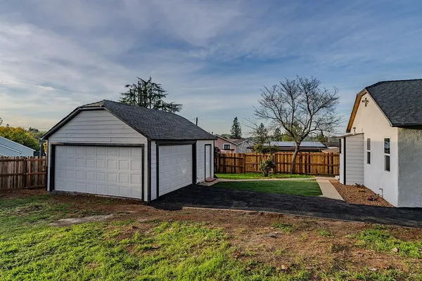a view of a white house with a large tree
