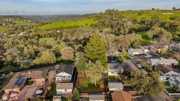 a view of a house with a small yard and wooden fence