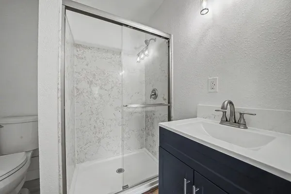 an empty room with wooden floor ceiling fan and windows