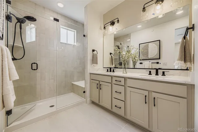 a bathroom with a double vanity sink mirror double and shower
