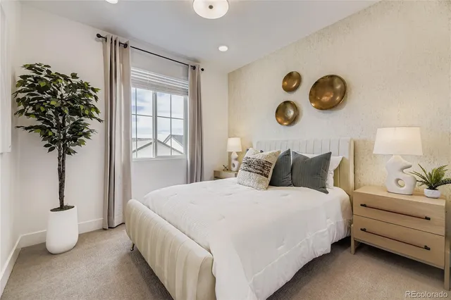 a bedroom with bed and a potted plant